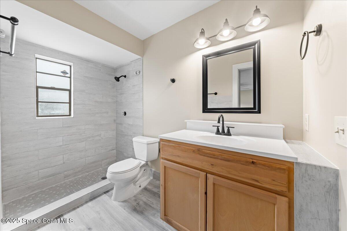 2010 Talloak Road Melbourne, FL 32935 - Photo 12 of 45 a view of bathroom with a toilet sink mirror and vanity