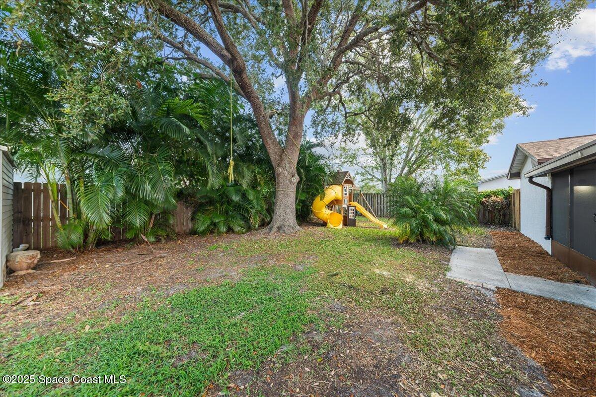 2010 Talloak Road Melbourne, FL 32935 - Photo 20 of 45 a view of a yard with a tree and a slide