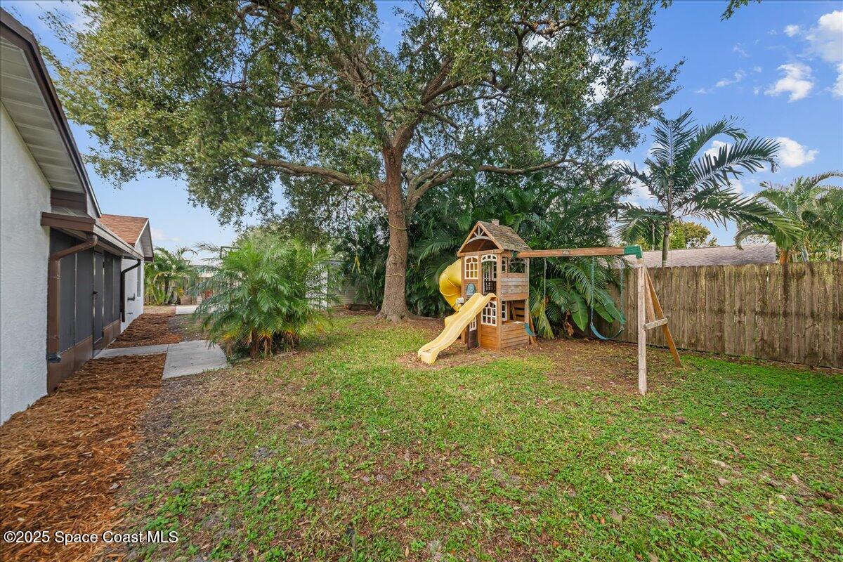 2010 Talloak Road Melbourne, FL 32935 - Photo 26 of 45 a view of a backyard with swings and slides