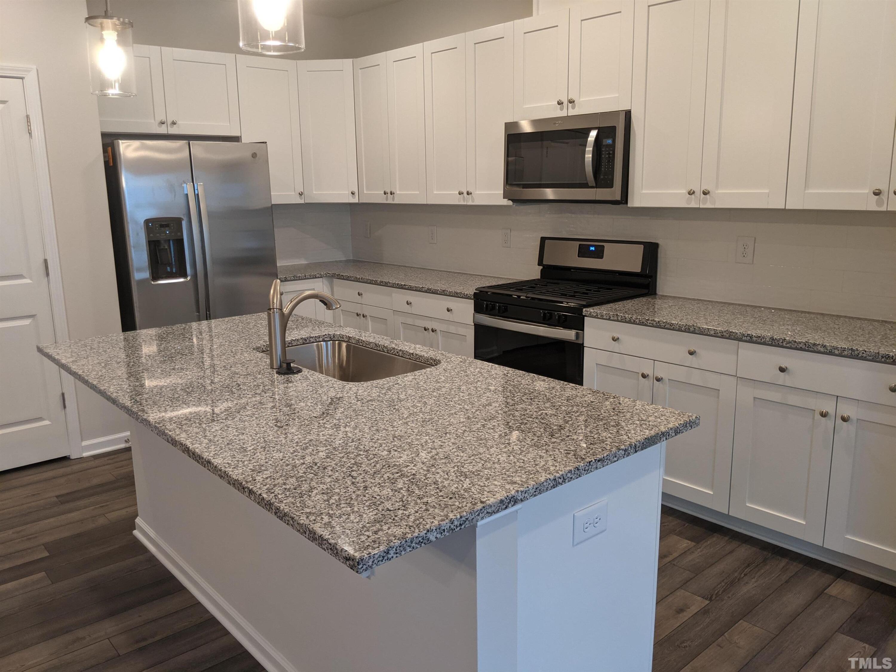 912 Robbie Jackson Lane Fuquay-Varina, NC 27526 - Photo 3 of 10 a kitchen with stainless steel appliances granite countertop a sink a stove and a granite counter top