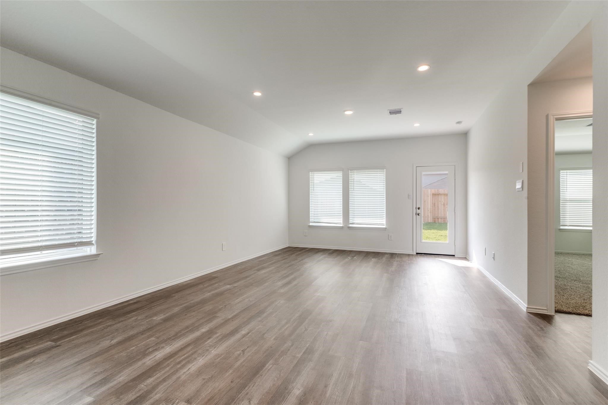 24323 Cayman Heights Lane Spring, TX 77373 - Photo 8 of 12 an empty room with wooden floor and windows