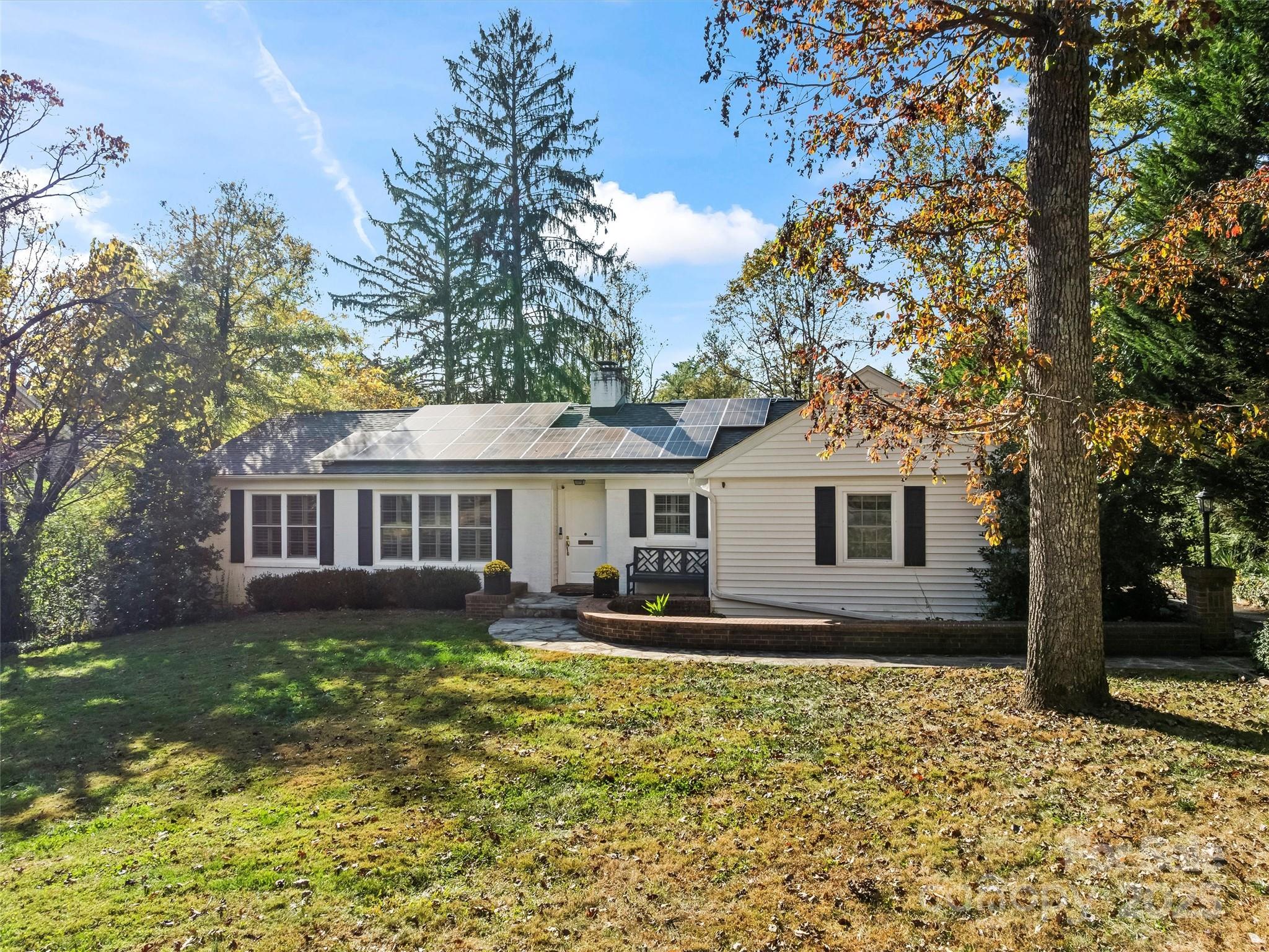 9 Hilltop Road Asheville, NC 28803 - Photo 1 of 34 a front view of a house with a yard table and chairs