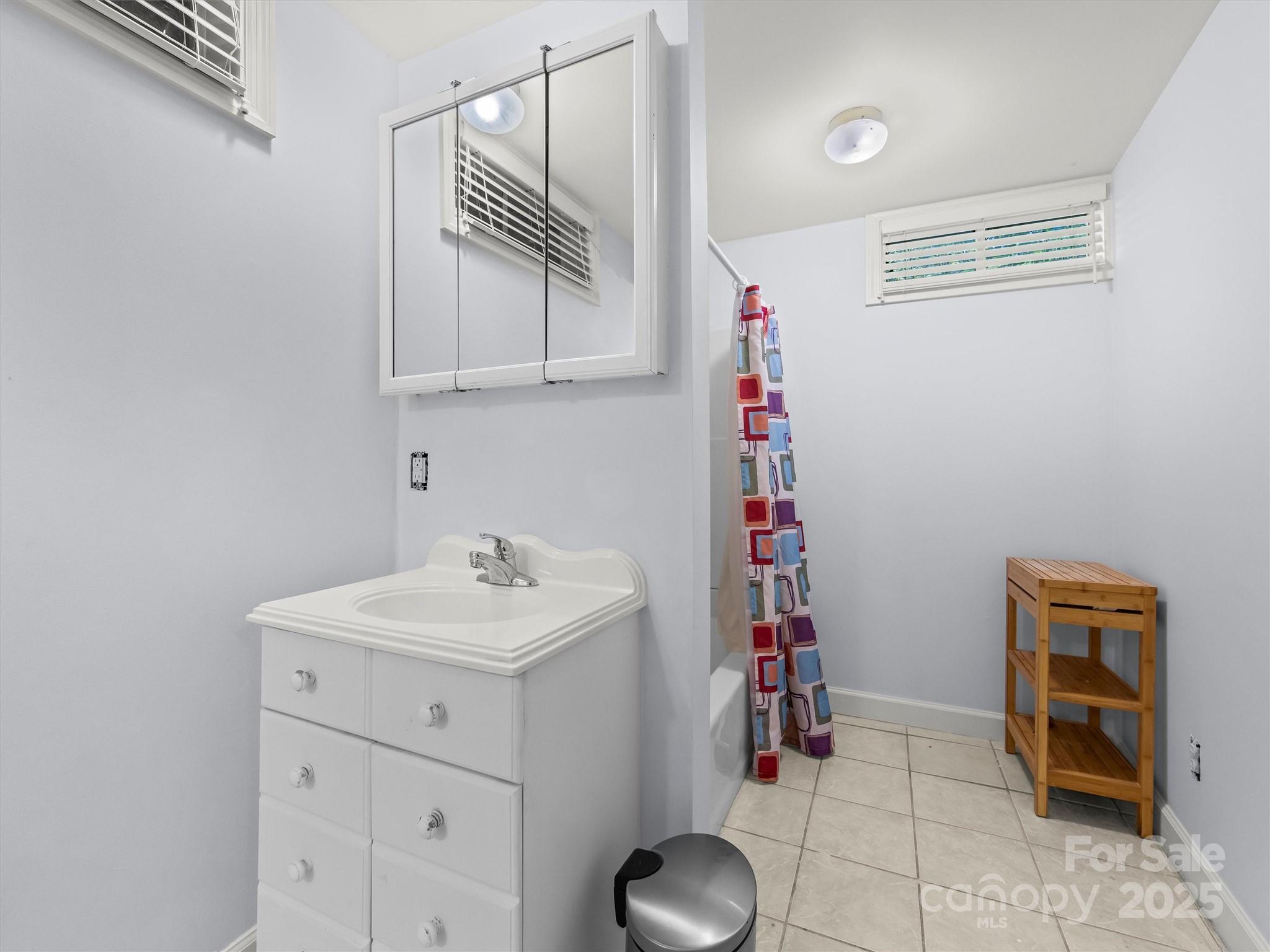 9 Hilltop Road Asheville, NC 28803 - Photo 28 of 34 a bathroom with a sink a vanity and mirror