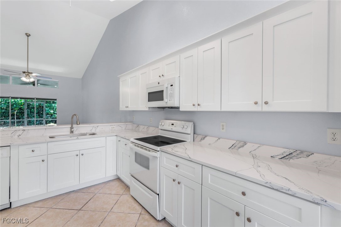 5781-5783 Marina Road Bokeelia, FL 33922 - Photo 12 of 48 a kitchen with white cabinets sink and white appliances