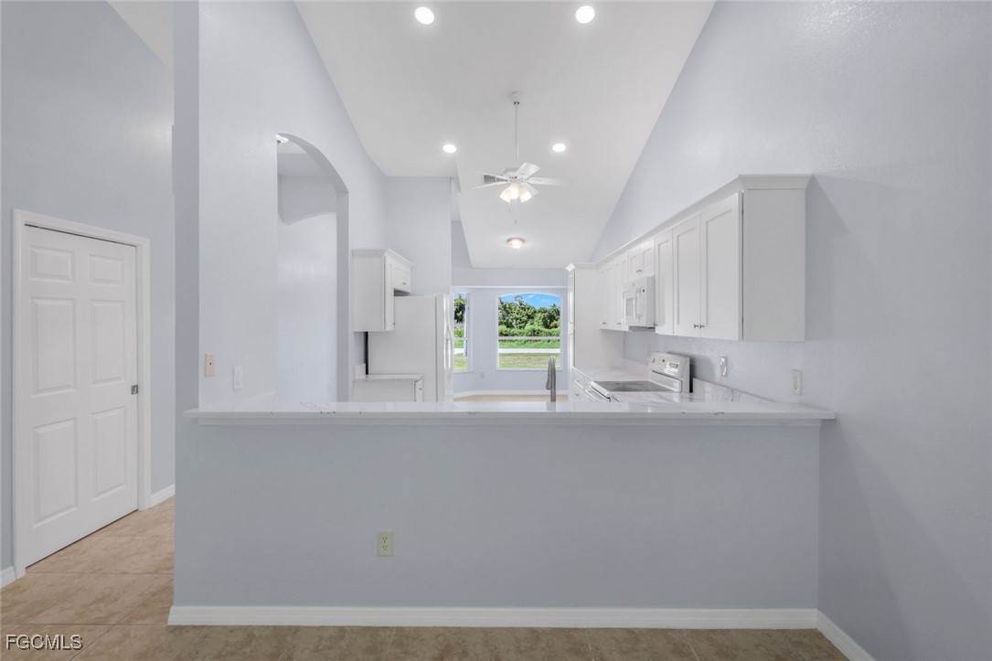 5781-5783 Marina Road Bokeelia, FL 33922 - Photo 31 of 48 a kitchen with stainless steel appliances granite countertop a sink a stove and a refrigerator