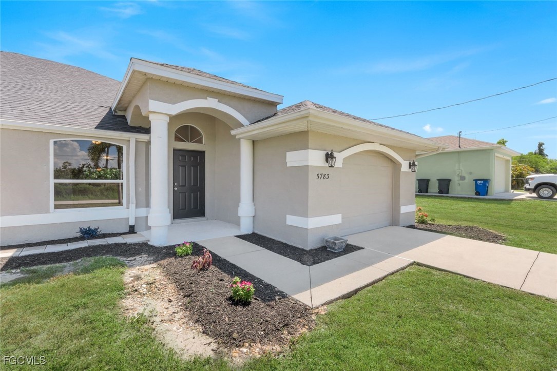 5781-5783 Marina Road Bokeelia, FL 33922 - Photo 5 of 48 a front view of a house with a yard