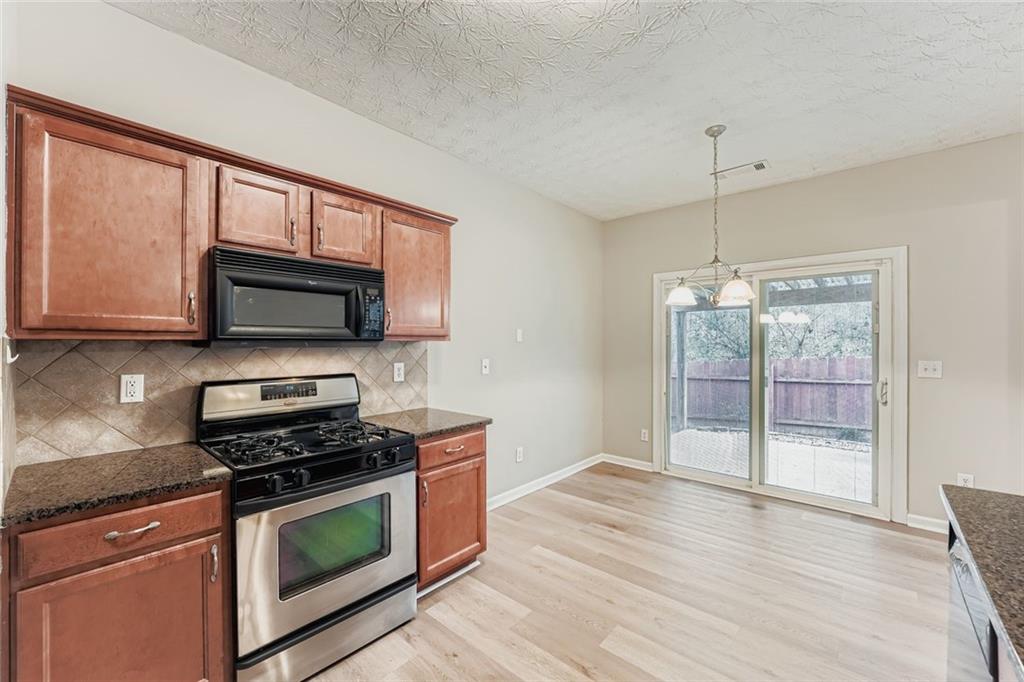 104 Oleander Way Canton, GA 30114 - Photo 13 of 28 a kitchen with stainless steel appliances granite countertop a stove and a microwave