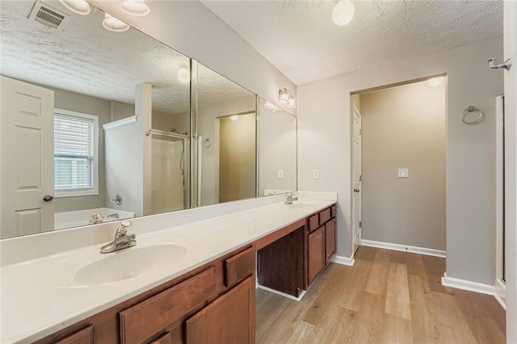 104 Oleander Way Canton, GA 30114 - Photo 18 of 28 a bathroom with a sink double vanity granite tub shower and a mirror