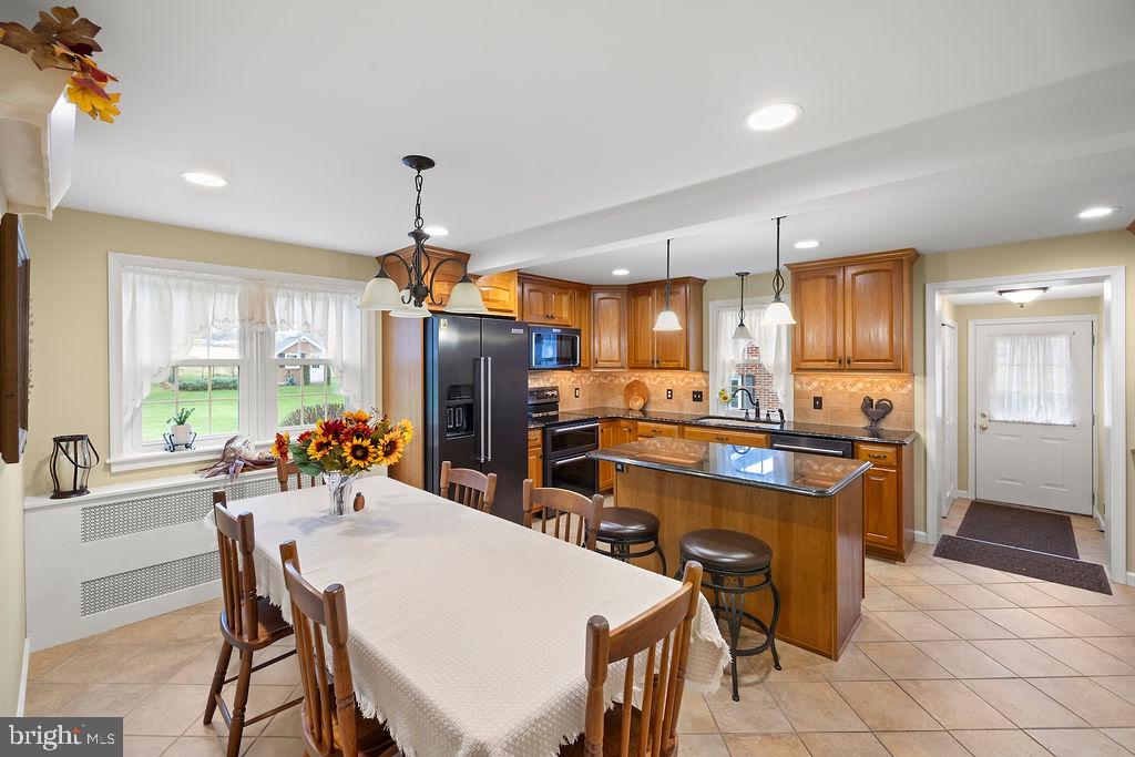 503 Main Street York Springs, PA 17372 - Photo 27 of 62 a kitchen with stainless steel appliances a dining table chairs stove refrigerator and cabinets