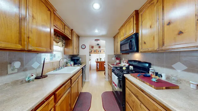 a kitchen with stainless steel appliances granite countertop a sink stove and cabinets