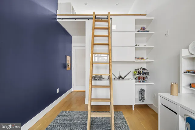 a bedroom with a bed and a wooden floor