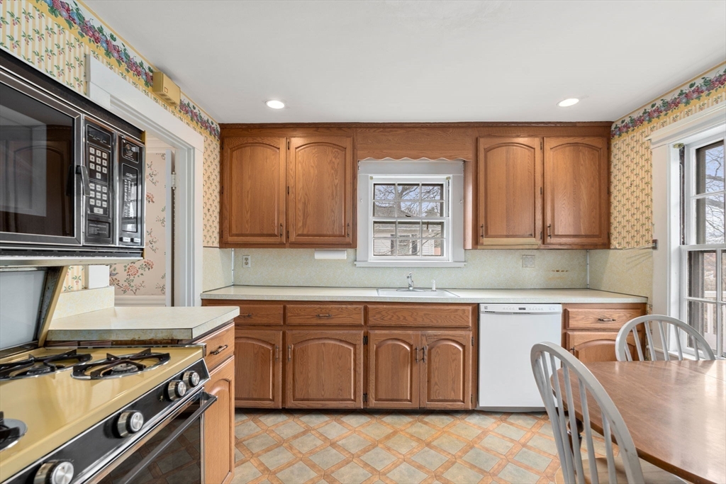 22 Arden Road Newton, MA 02460 - Photo 14 of 28 a kitchen with stainless steel appliances granite countertop a stove a sink dishwasher and a microwave oven with wooden cabinets