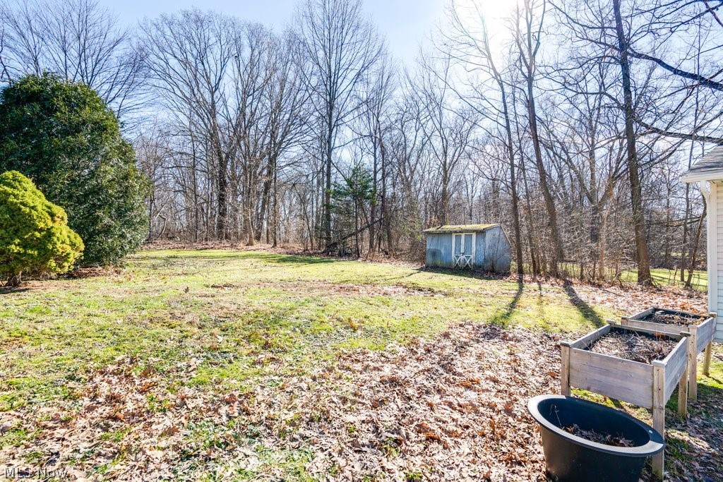151 Meadowridge Road Mogadore, OH 44260 - Photo 24 of 26 View of green lawn with a garden and a storage unit