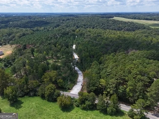 an aerial view of a houses with a yard and trees