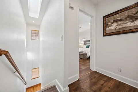 a view of a hallway with wooden floor and closet