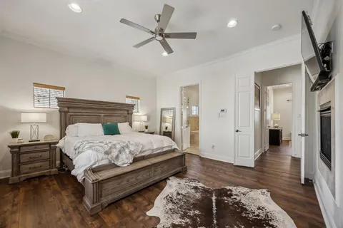 a bedroom with a bed and a dresser with wooden floor