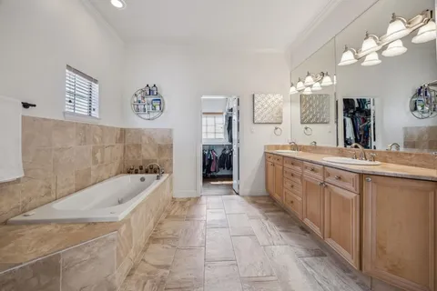 a spacious bathroom with a tub sink and a mirror