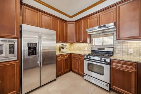 a kitchen with stainless steel appliances granite countertop a refrigerator sink and cabinets