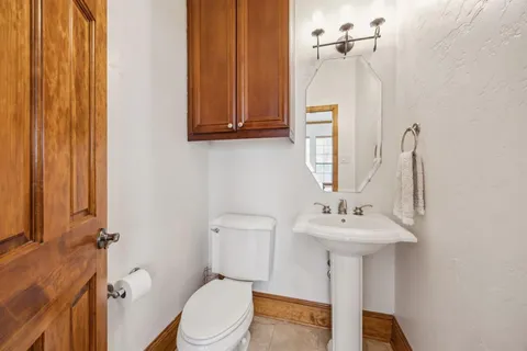 a bathroom with a sink a toilet and mirror