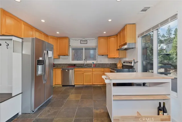 a kitchen with granite countertop stainless steel appliances a sink and counter space