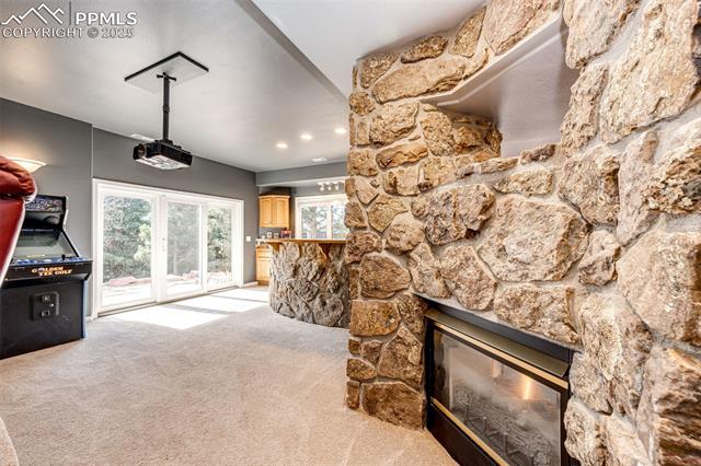 19340 Furrow Road Monument, CO 80132 - Photo 42 of 50 Living room with a stone fireplace and light carpet