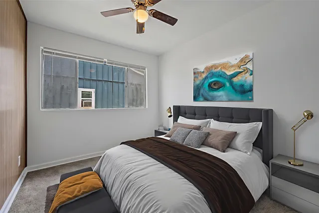 a bedroom with a bed and a painting on the wall