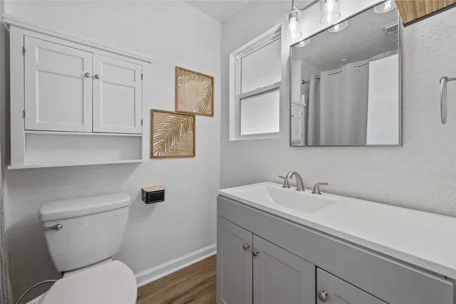 a bathroom with a toilet sink and mirror