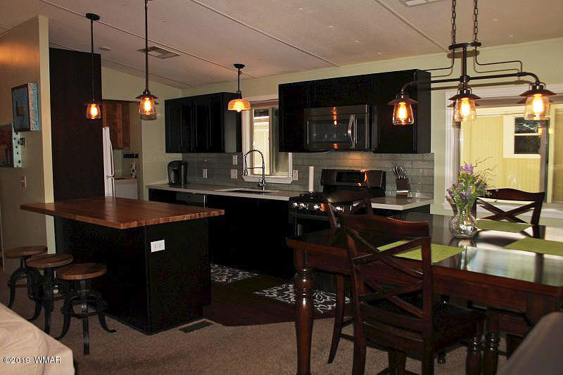 5472 North Blue Ridge Loop Pinetop, AZ 85935 - Photo 9 of 22 a kitchen with a table chairs and a refrigerator