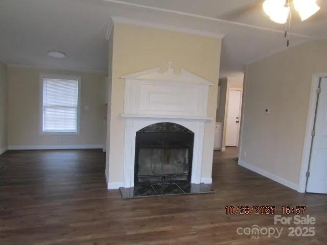 a view of empty room with wooden floor and fireplace