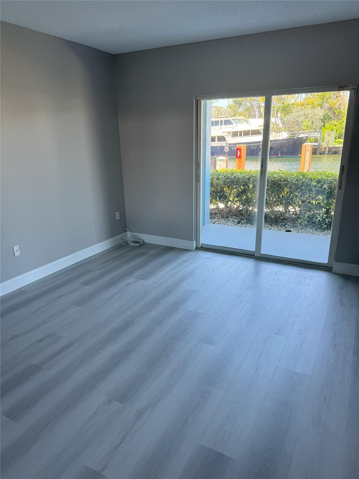 2731 Northeast 28th Court, Unit 3 Lighthouse Point, FL 33064 - Photo 30 of 33 a view of an empty room with wooden floor and a window