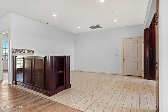a view of an empty room with wooden floor and entryway
