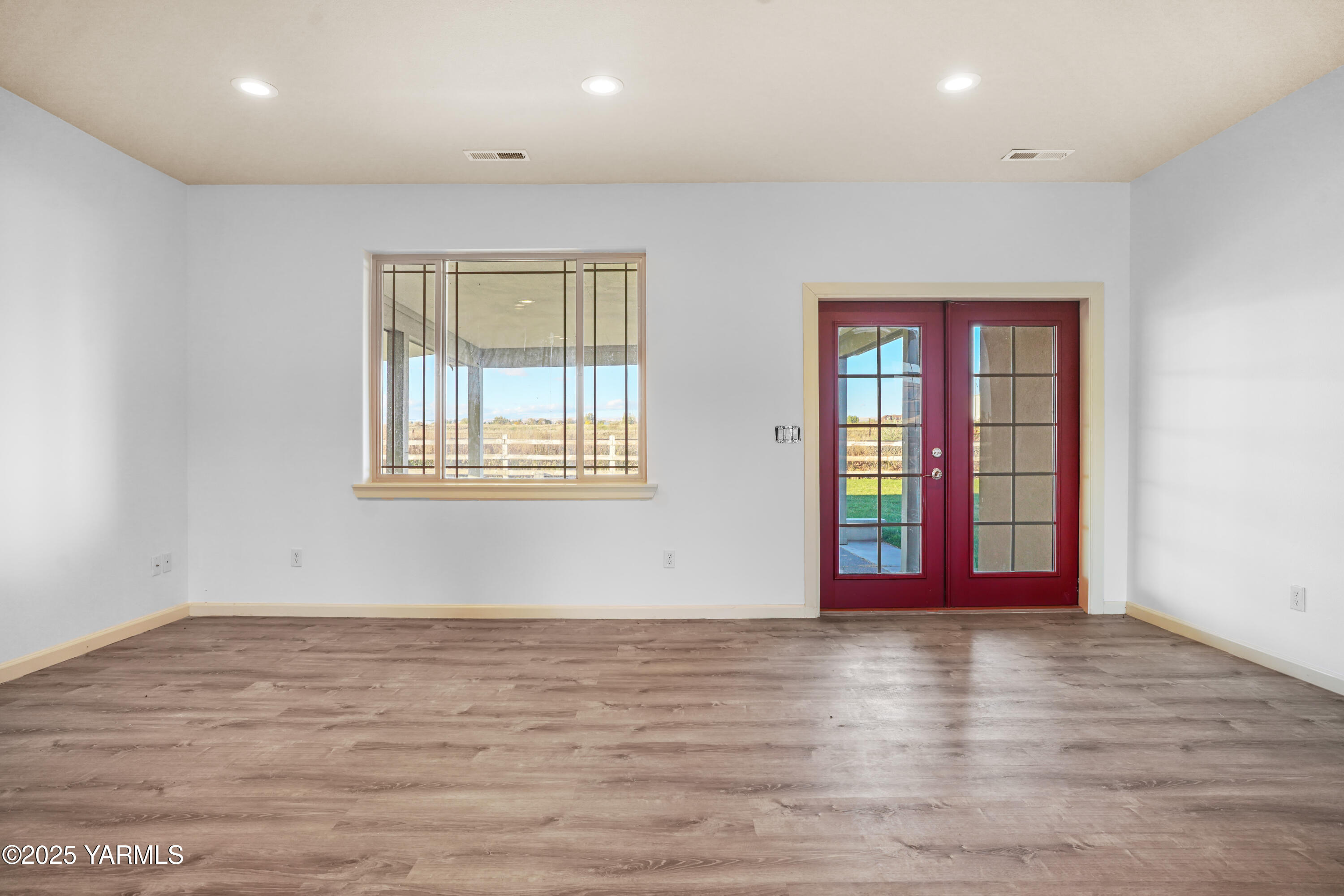 10002 North Wamba Road Prosser, WA 99350 - Photo 29 of 40 an empty room with wooden floor and windows