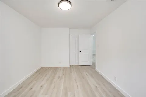 a view of room with wooden floor and white walls