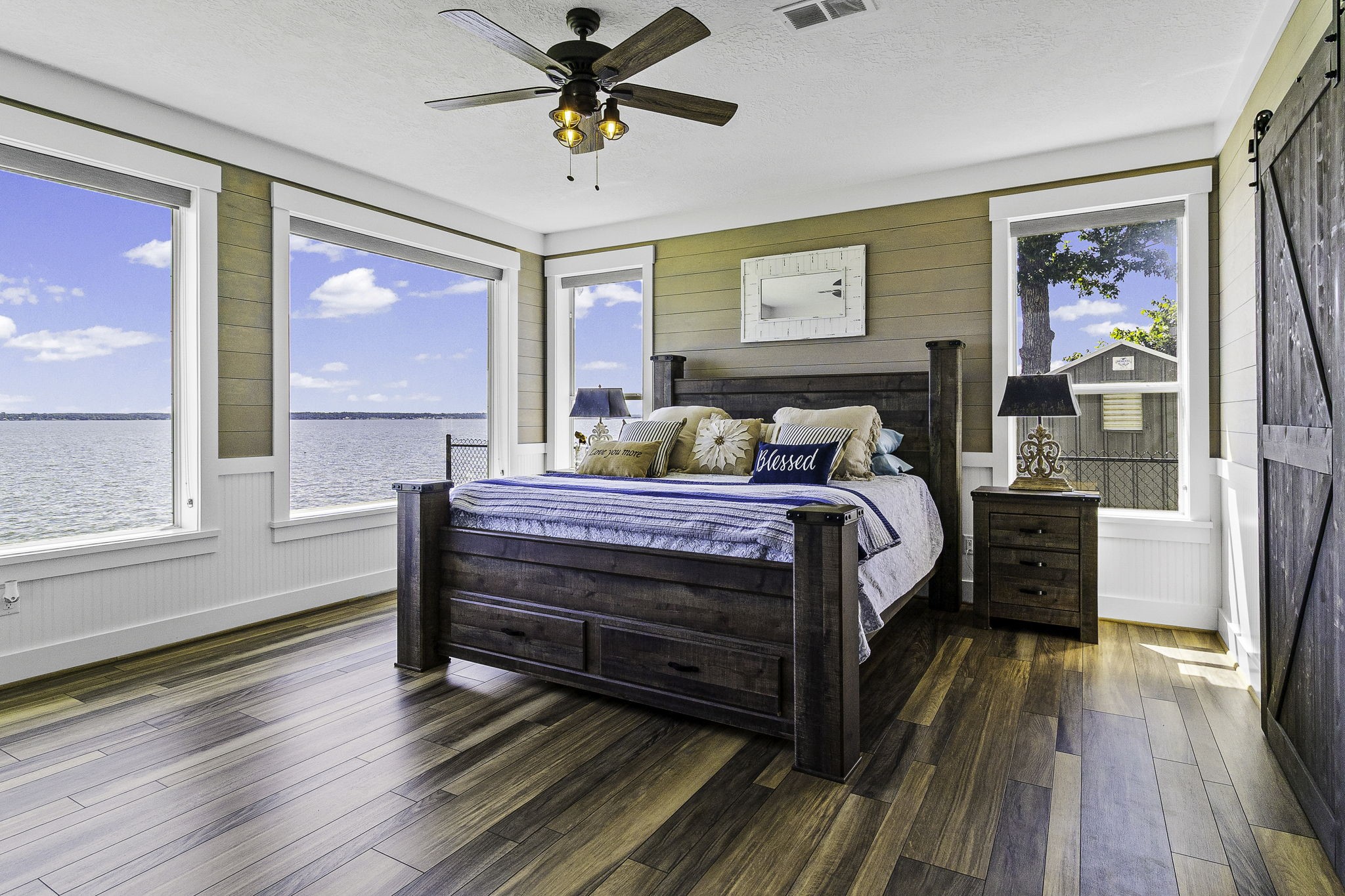 151 Key Largo Loop Point Blank, TX 77364 - Photo 16 of 49 Wake up to breathtaking panoramic lake views from this spacious water-primary suite featuring walls of windows and beautiful wood flooring.