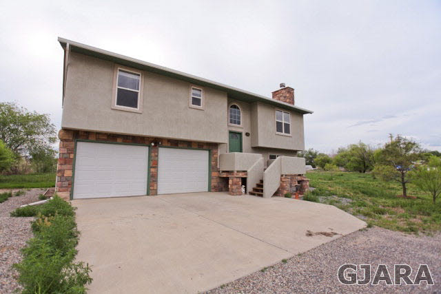 579 29 Road Grand Junction, CO 81501 - Photo 6 of 40 a front view of a house with a yard and garage