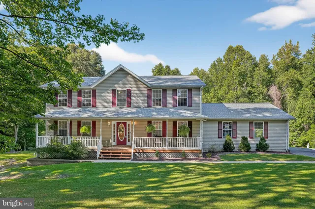 a front view of a house with a garden and trees