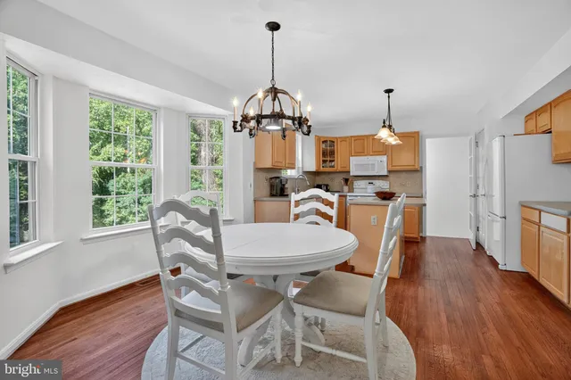 a dining room with furniture a chandelier and wooden floor
