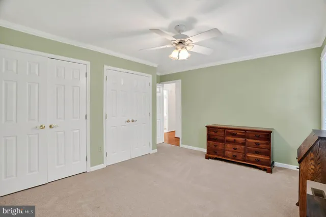 a view of an empty room with a chandelier fan