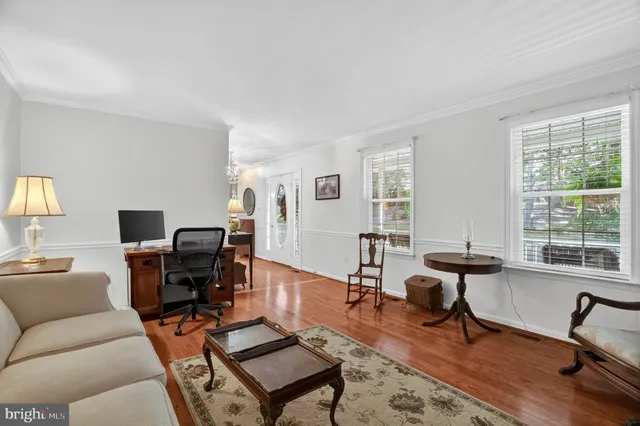 a living room with furniture a flat screen tv and a window