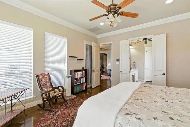 a bedroom with a large bed a chandelier and dresser