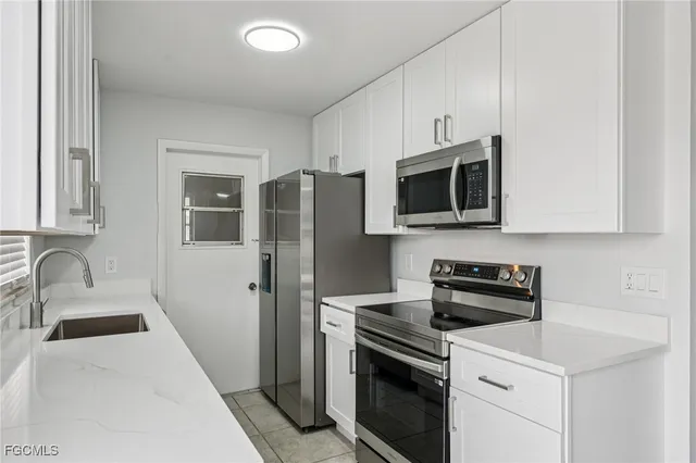 a kitchen with stainless steel appliances a stove microwave sink and refrigerator