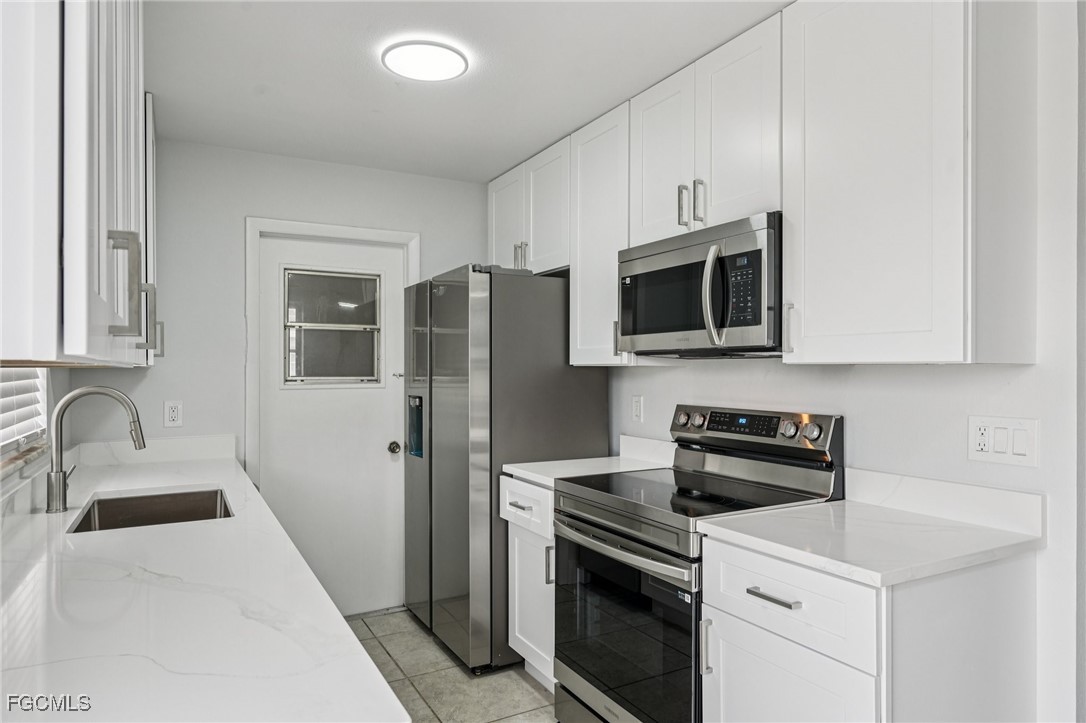 2342 Aldridge Avenue Fort Myers, FL 33907 - Photo 8 of 21 a kitchen with stainless steel appliances a stove microwave sink and refrigerator