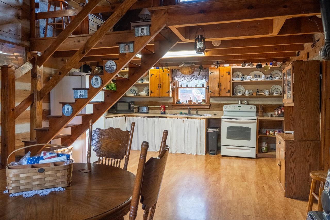 800 Cove Mountain Road Mathias, WV 26812 - Photo 14 of 74 a view of a kitchen with kitchen island a stove a wooden floor and a dining table