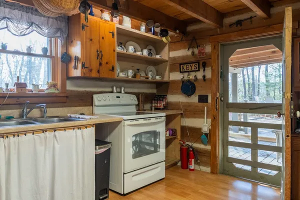 a view of a kitchen with kitchen island a stove a wooden floor and a dining table
