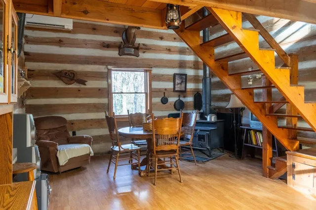 a view of a kitchen with kitchen island a stove a wooden floor and a dining table