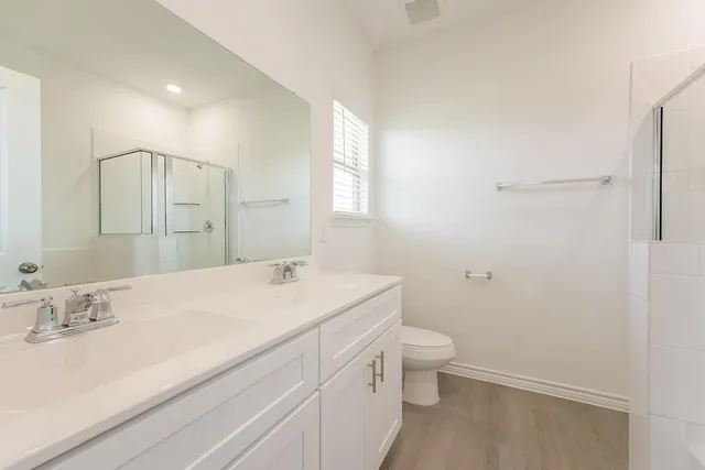 a bathroom with a sink a toilet and a large mirror