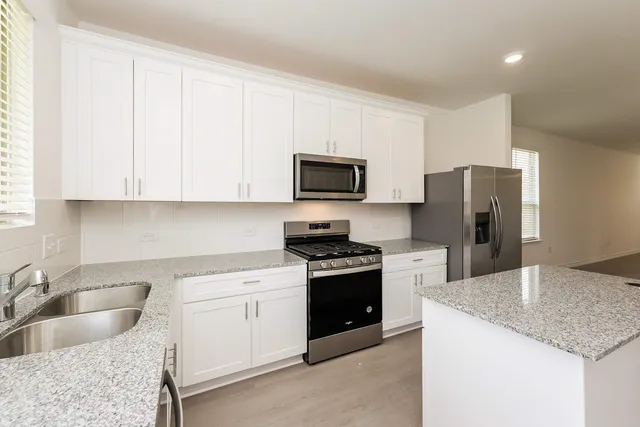 a kitchen with a sink stove and refrigerator