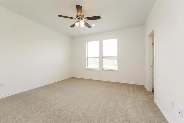 an empty room with a window and a fan