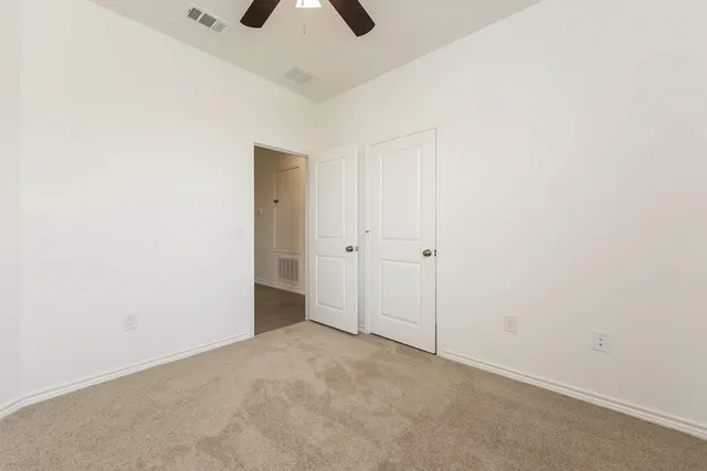 an empty room with chandelier fan