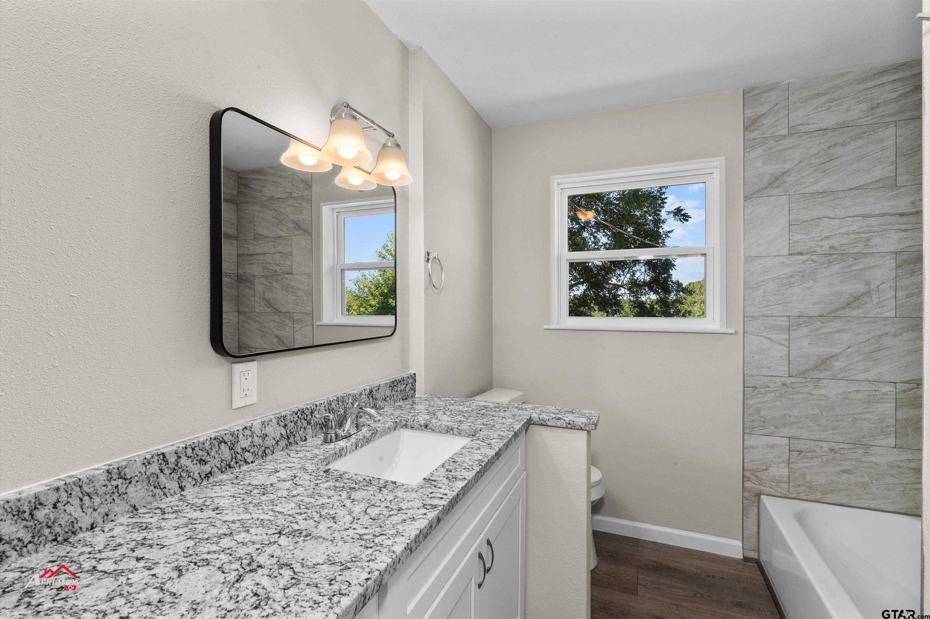6973 FM 449 Marshall, TX 75670 - Photo 13 of 29 a bathroom with a granite countertop sink and a mirror